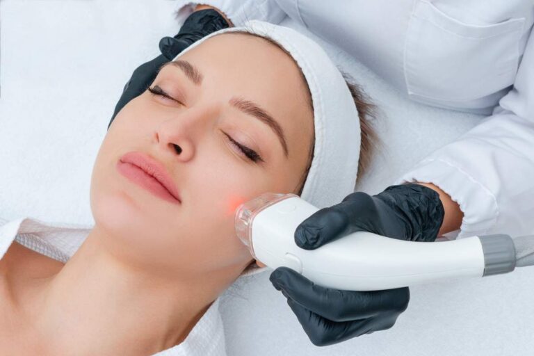 A person gently applying fragrance-free moisturizer to their face in a well-lit bathroom.